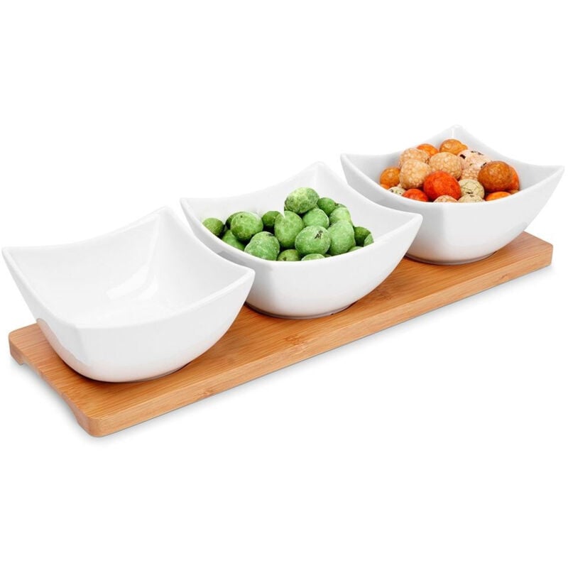 Three elegant porcelain bowls on a bamboo tray for snacks and dips